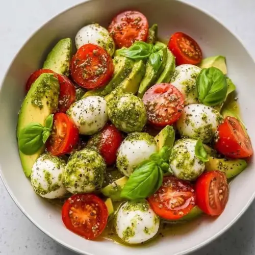 Creamy avocado caprese salad with fresh tomatoes and mozzarella